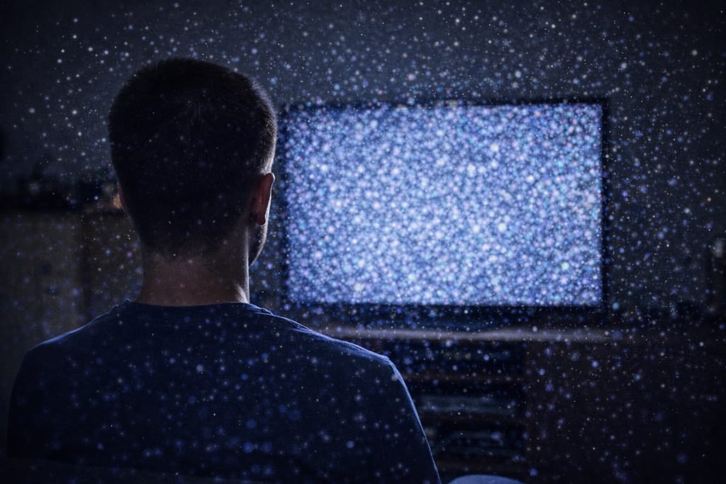 Man seeing visual snow static in his field of vision while looking at a bright screen, representing Visual Snow Syndrome.