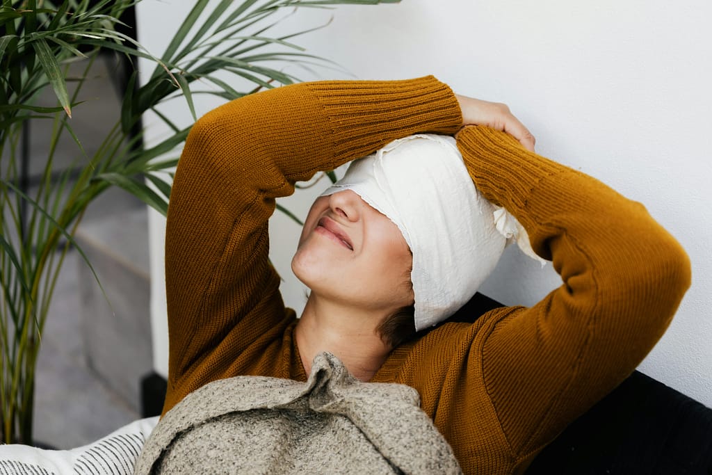 Woman applying warm compress to relieve eye pain behind the eyes