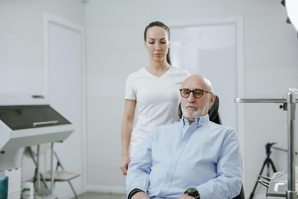 Adult patient discussing eye exam frequency and presbyopia with an optometrist.