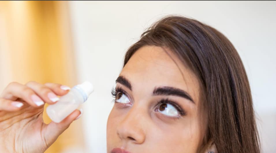 close up woman applying non-preservative eye drops correct technique